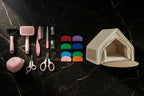 Pink grooming tools, coloured pouch squeezers and a beige tent-style hideaway arranged on black marble.