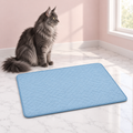 Quilted Cat Mat, 3 Sizes – The AeroMat Chill Pad, M size shown, with a smoky grey Maine Coon in an empty light pink room.