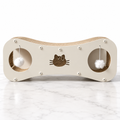 Cream Paw-villian figure-8 cat scratcher with two hanging pom-poms on white marble flooring