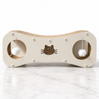 Cream Paw-villian figure-8 cat scratcher with two hanging pom-poms on white marble flooring