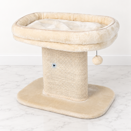 Beige low cat perch with plush raised bed, sisal scratching panel and hanging ball on light marble flooring