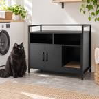 Black litter cabinet beside a full-sized black Norwegian Forest Cat in a utility room