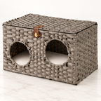 The Woven Retreat grey rattan cat house on a pale white-marble studio floor