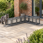 Full-sized blue Maine Coon beside the dark grey modular cat tunnel on a garden terrace