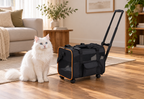 Compact black rolling pet carrier beside a full-sized solid white Siberian cat in a sitting room