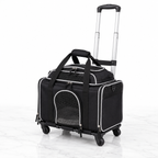 Black low-profile rolling pet carrier with silver piping on a light white marble background