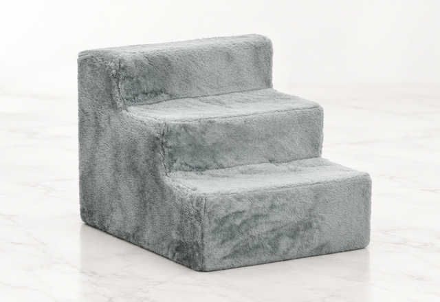 Light-grey three-step plush pet stairs on a light white marble background