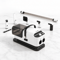 White and grey grooming vacuum with five tools, four clipper guards and detached hose on white marble