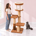 Cat Tree 166 cm – The Amber Rise with a smoky grey Maine Coon and an adult woman facing the tower in an empty light pink room with white marble flooring.