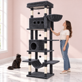 Maine Coon Cat Tree 211cm | XL Cat Tower – Cat-Cave in an empty light pink room with white marble flooring and a black Maine Coon looking toward the product.