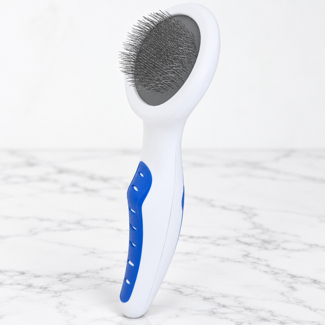 Cat Slicker Brush with Comfort Grip on white marble